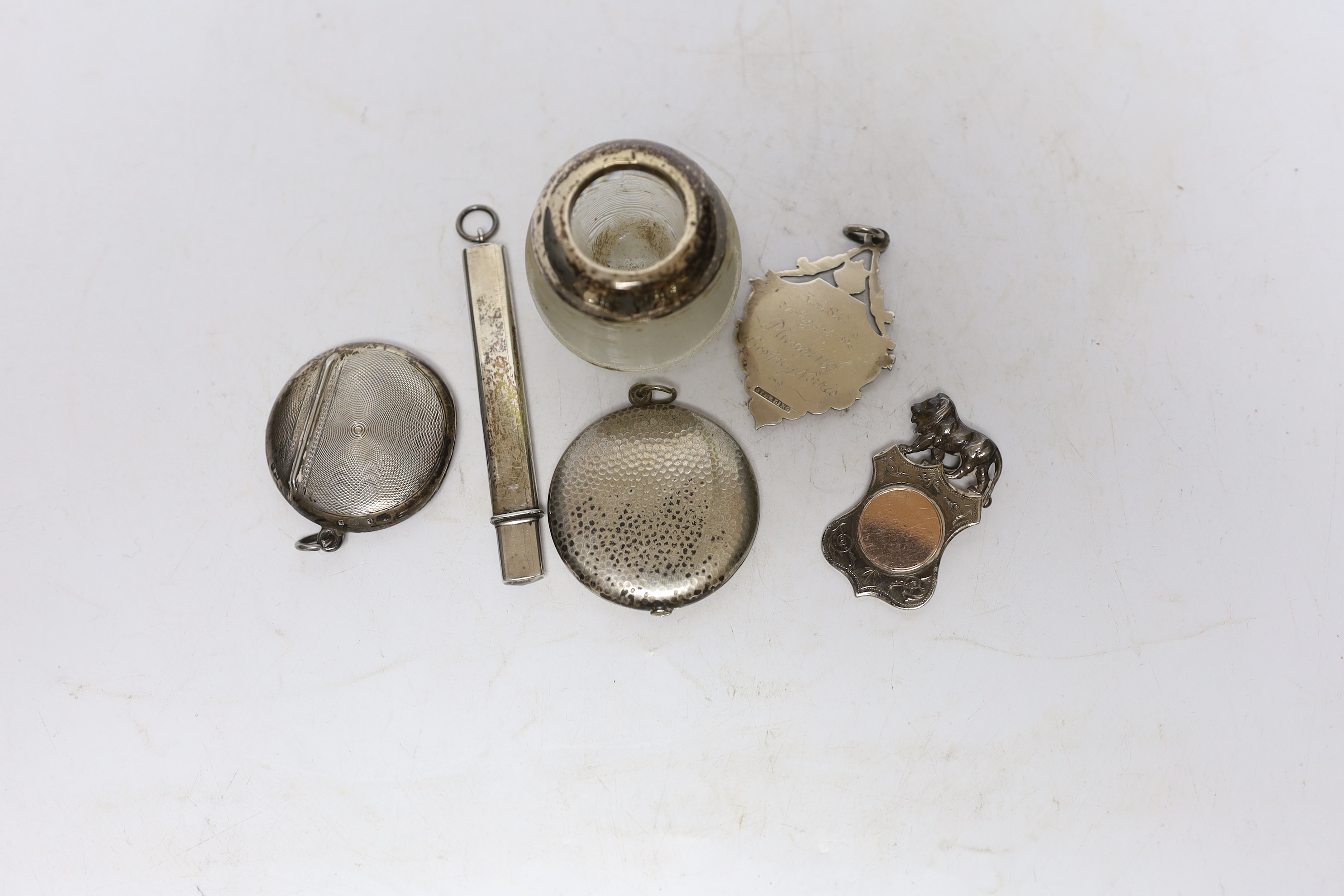 An early 20th century silver mounted ribbed glass match strike, 47mm and five other items including a silver vesta case, white metal locket, two medallions and a pencil.